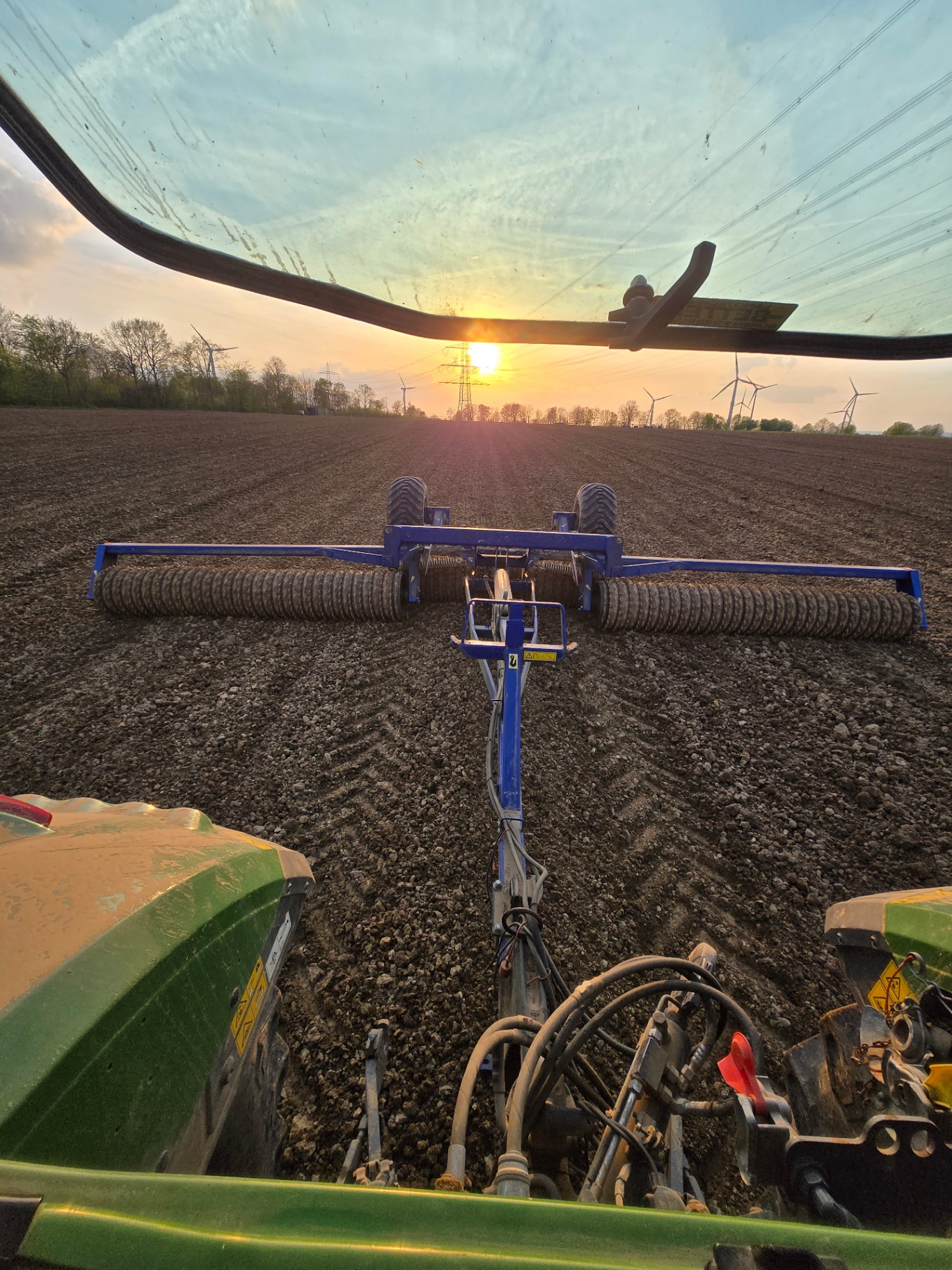 Blick aus der Fahrerkabine bei Sonnenuntergang auf dem Feld